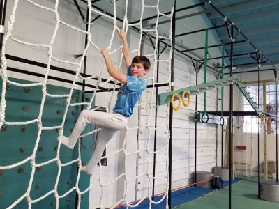 Teen boy climbing a rope ladder